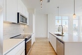 Located at 1500 Westbranch Dr in McLean, VA, this well-appointed 3-bedroom, 2-bathroom residence offers a thoughtfully designed single-floor layout with a clean, contemporary aesthetic throughout. Light wood-tone flooring flows seamlessly across the entire space, complementing bright white walls and modern finishes.

The open-concept living, dining, and kitchen area serves as the heart of the home. The chef's kitchen is a standout feature, showcasing sleek white flat-panel cabinetry, a tiled backsplash, stainless steel appliances, and a generous central island with a white quartz countertop and an undermount sink — illuminated by stylish pendant lighting. Floor-to-ceiling windows flood the living area with abundant natural light and offer sweeping urban views of the McLean skyline.

The primary bedroom is a spacious retreat with direct access to a luxurious en-suite bathroom, which features marble-look tile flooring, a double vanity, a glass-enclosed shower, and a soaking tub. Additional bedrooms are bright and well-proportioned, each with windows framing outdoor views.

Two hallways connect the well-organized layout, which includes an impressive eight closets — many outfitted with wire shelving systems — offering exceptional storage throughout. A dedicated laundry room with a full-size washer adds everyday convenience to this polished McLean residence.