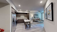 Located at 10110 Foothill Blvd in Rancho Cucamonga, California, this single-floor residence offers a thoughtfully designed open-concept layout with modern finishes throughout. Light wood-look flooring flows seamlessly through the main living areas, contributing to a clean, contemporary aesthetic.

The living room is a comfortable and well-lit space, featuring a ceiling fan, recessed lighting, and large windows that invite abundant natural light. A sliding glass door connects the living area to an outdoor balcony, enhancing the sense of openness. The space transitions effortlessly into the dining and kitchen areas, creating an ideal layout for both everyday living and entertaining.

The kitchen is a standout feature, outfitted with dark wood-grain cabinetry, quartz countertops, a glass tile backsplash, and a full suite of stainless steel appliances including a gas range, built-in microwave, and French door refrigerator. A central island with bar seating provides additional prep space and casual dining options.

The bedroom offers a calm retreat with plush carpeting, a ceiling fan, and a window with natural light. The bathroom is finished in crisp white tile, featuring a full soaking tub and shower combination with chrome fixtures and clean, minimalist detailing. A closet with storage access completes the private quarters.