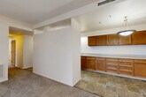 Located at 4212 NE Broadway in Portland's vibrant northeast corridor, this single-floor, two-bedroom residence offers a practical and well-organized layout. The kitchen is a standout feature, offering ample warm-toned wood cabinetry extending both above and below the countertops, generous laminate counter space, a utility sink, and tile flooring. A half-wall partition visually separates the kitchen area from the adjacent living space, creating a semi-open feel while maintaining defined zones. A hallway connects the main living areas to the two bedrooms, each finished with wall-to-wall carpet for comfort underfoot. The primary bedroom is generously sized, featuring large windows dressed with vertical blinds that allow for natural light and outdoor views. Both bedrooms include built-in closets with hanging rods, providing practical storage. The secondary bedroom also benefits from a wide window, maintaining a bright and airy atmosphere. Throughout the unit, neutral tones on the walls and ceilings create a clean, versatile backdrop. Textured ceilings are present in select areas, adding a classic residential character. The tile-floored entryway and hallway provide a durable transition between rooms, completing this functional and comfortable Portland residence.