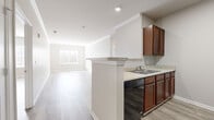 Located at 708 Glamorgan Way in Rock Hill, South Carolina, this single-floor home offers a clean, contemporary design with a cohesive neutral color palette and light wood-style flooring throughout. The open-concept living area is bright and spacious, enhanced by crown molding, recessed lighting, and natural light streaming through windows fitted with white blinds. The kitchen features rich, warm-toned cabinetry, light granite-style countertops, a double-basin sink, a black dishwasher, and a full-size refrigerator, all connected to the living space via a peninsula-style counter that encourages an easy flow between areas. The bedrooms are well-proportioned, each offering natural light through individual windows and the same consistent flooring found throughout the home. Both bathrooms are functionally designed, featuring warm wood-toned vanities with light countertops, large mirrors, tub-shower combos, and matching light flooring that ties the aesthetic together. The neutral, warm-gray wall tones used across the home create a calm and welcoming atmosphere, while the clean finishes and open layout make the space highly versatile and move-in ready.