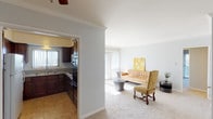 Located in the Clairemont neighborhood of San Diego, this single-level unit offers a well-organized layout that balances functional living spaces with comfortable design details throughout. The living room serves as the heart of the home, featuring soft neutral carpet, crown molding, and a sliding glass door that opens to a private balcony with expansive outdoor views of the surrounding landscape. Natural light flows generously through vertical blinds, lending the space a bright and airy feel.

The kitchen is thoughtfully appointed with rich dark wood cabinetry, granite-style countertops, and a full suite of appliances including a gas range, built-in microwave, and refrigerator. Tile flooring and a double-basin sink complete the practical design. A pass-through opening connects the kitchen visually to the living area, enhancing the sense of openness.

The bedrooms are carpeted and finished in soft, neutral tones. One bedroom features a distinctive shiplap accent wall, adding a subtle architectural detail, while another includes a ceiling fan and closet. Each room is calm and versatile in its use. The bathroom is clean and functional, featuring a tub and shower combination with sliding glass doors and granite-style countertops. Ceiling fans are present throughout, contributing to year-round comfort in this well-maintained San Diego residence.