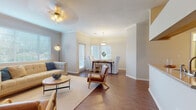 This single-floor residence offers a thoughtfully designed layout that balances comfort and functionality across its key living spaces. The open-concept living and dining area serves as the heart of the home, featuring rich wood-look flooring, crown molding, and a ceiling fan that add a polished finish. Large windows dressed with white blinds flood the space with natural light, creating a bright and welcoming ambiance throughout.

The living room provides generous space for relaxation, with crown molding accents and multiple windows that invite the outdoors in. It flows seamlessly into a dedicated dining area, illuminated by a pendant light fixture and framed by additional windows that enhance the airy feel.

The galley-style kitchen is efficiently arranged with light maple cabinetry, granite-look countertops, stainless steel appliances including a refrigerator, range, microwave, and dishwasher, and a stainless steel sink — offering everything needed for everyday cooking.

Both bedrooms are carpeted for comfort and feature ceiling fans and natural light from well-placed windows. One bedroom includes access to a walk-in closet, providing ample storage. The full bathroom is clean and functional, featuring a single vanity with a granite-look countertop, white cabinetry, and a shower-tub combination.