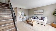Located at 2140 S Palmetto Ave in South Daytona, FL, this two-story, two-bedroom, two-bathroom home is thoughtfully laid out across two floors. The main level features a welcoming living room finished with light tile flooring, neutral taupe walls, and a textured ceiling, creating a clean and airy atmosphere. A black iron staircase adds a contemporary accent as it leads to the upper level. The kitchen is equipped with white cabinetry, granite-look countertops, and tile flooring, offering a functional and bright workspace. Adjacent to the kitchen, the dining area benefits from a sliding glass door that invites natural light and provides direct access to the outdoor patio. A half bathroom on the main floor adds convenience for guests. Upstairs, both bedrooms feature warm wood-look laminate flooring and soft neutral tones. The spacious primary bedroom offers comfortable proportions and a natural light source through a window with blinds. The second bedroom is equally well-appointed. A full bathroom on the upper level includes a tub-shower combination with tile surround and a vanity with storage. Closets on the upper level provide ample storage throughout. The overall aesthetic is cohesive, calm, and move-in ready.