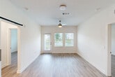 Located on Blanding Blvd in Jacksonville, FL, this single-story 2-bedroom, 1-bathroom home offers a clean, modern design with light wood-style flooring that flows consistently throughout. The kitchen is a standout feature, showcasing two-tone cabinetry with white upper cabinets and gray lower cabinets, granite-style countertops, open shelving, and a full suite of stainless steel appliances including a refrigerator with ice maker, electric range, microwave, and dishwasher. The spacious primary bedroom includes a ceiling fan, a bright window with outdoor views, and direct access to a generously sized walk-in closet outfitted with multi-tiered wire shelving systems. A second closet offers additional storage. The bathroom features a full soaking tub and shower combination with white tile surround and brushed gold fixtures, complemented by granite-topped vanity cabinetry. A dedicated laundry room houses a full-size washer and dryer along with an elevated water heater. Clean white walls, recessed lighting, and a bright, airy atmosphere define the overall ambiance of this thoughtfully designed home.