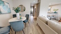 Located at The Manning in Indianapolis, Indiana, this one-bedroom, one-bathroom unit delivers a well-organized and stylish living experience across a single floor. The open-concept living and dining area forms the heart of the home, featuring light wood-style flooring, neutral walls, and a teal accent wall that adds a pop of color. The living room benefits from a large sliding glass door that fills the space with natural light and provides outdoor views. A dedicated dining area adjacent to the living room offers an intimate setting, complemented by pendant lighting overhead. The kitchen is efficiently designed with white cabinetry, granite-style countertops, and stainless steel appliances, providing both functionality and a clean aesthetic. A hallway connects the main living areas to the private bedroom, which is generously proportioned and features plush carpeting, a bold teal accent wall, and a window with outdoor views. The bedroom is paired with a walk-in closet outfitted with built-in shelving and hanging rods, offering ample storage. The full bathroom includes a shower/tub combination with tiled surround and wood-style flooring. Throughout the unit, a cohesive teal and neutral color palette creates a calm, modern atmosphere.