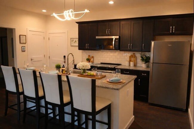 Cocina con isla, encimeras de granito y electrodomésticos de acero inoxidable. - The Pinnacle at Swiftwater