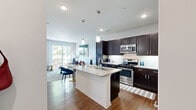 Located at 401 Janes Ave in Bolingbrook, IL, this well-appointed one-bedroom, one-bathroom residence offers a smartly utilized single-floor layout with a bright, open-concept design. The kitchen is a standout feature, showcasing rich dark espresso cabinetry, white quartz countertops, a subway tile backsplash, stainless steel appliances including a gas range and built-in microwave, and a central island with a sink — ideal for both cooking and entertaining. The kitchen flows seamlessly into the combined dining and living area, where hardwood-style flooring, recessed lighting, and access to a private balcony create an inviting atmosphere filled with natural light. The living room features a striking striped accent wall, adding a stylish focal point to the space. The bedroom is generously proportioned, with large windows offering outdoor views, plush carpeting, and a grid-pattern accent wall. Two closets provide ample storage. The bathroom is finished with a dark wood vanity, quartz countertop, and a tiled shower, maintaining the cohesive design language found throughout. A dedicated laundry area and a well-connected hallway complete the efficient and functional floor plan, making this residence a polished and comfortable living space.