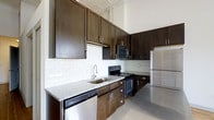 Located at 345 East Deshler Avenue in Columbus, Ohio, this single-floor space combines modern finishes with functional design. The kitchen is a standout feature, showcasing rich dark-espresso cabinetry that extends floor to ceiling, taking full advantage of the impressively tall ceilings. White subway tile backsplash provides a crisp contrast against the cabinetry, while light granite countertops add a refined, elegant touch. A full suite of stainless steel appliances — including a refrigerator, electric range, built-in microwave, and dishwasher — ensures the kitchen is as practical as it is visually striking. Polished concrete-style flooring runs throughout, lending the space an industrial yet contemporary character that complements the overall aesthetic. The soaring ceiling height enhances the sense of openness and airiness, making the space feel expansive and inviting. The thoughtful layout and quality finishes throughout reflect a commitment to both style and functionality, making this Columbus property a compelling and well-rounded living space.