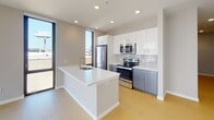Located at 121 N Second St in Philadelphia's historic Old City neighborhood, this modern unit offers a thoughtfully designed layout with clean, contemporary finishes throughout. Light wood-style flooring flows through the living and bedroom areas, complementing the neutral gray and white color palette.

The open-concept kitchen is a standout feature, anchored by a large center island with a white quartz countertop and an undermount sink. Stainless steel appliances — including a refrigerator, range, and built-in microwave — are paired with white upper cabinetry, slate-gray lower cabinets, and a classic subway tile backsplash. Floor-to-ceiling windows flood the kitchen and living area with natural light and frame striking views of the surrounding Philadelphia cityscape.

The bedrooms continue the bright, airy aesthetic, each featuring light flooring, recessed lighting, and tall windows that draw in abundant daylight and offer urban views. One bedroom includes a set of double closet doors for ample storage.

Two bathrooms serve the unit: one features large-format gray tile flooring, a soaking tub and shower combination, a sleek vanity with undermount sink, and recessed lighting; the other is outfitted with a glass-enclosed shower stall and dark tile flooring. Additional utility space rounds out this well-appointed urban residence.