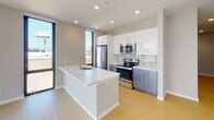 Located at 121 N Second St in Philadelphia's historic Old City neighborhood, this modern unit offers a thoughtfully designed layout with clean, contemporary finishes throughout. Light wood-style flooring flows through the living and bedroom areas, complementing the neutral gray and white color palette.

The open-concept kitchen is a standout feature, anchored by a large center island with a white quartz countertop and an undermount sink. Stainless steel appliances — including a refrigerator, range, and built-in microwave — are paired with white upper cabinetry, slate-gray lower cabinets, and a classic subway tile backsplash. Floor-to-ceiling windows flood the kitchen and living area with natural light and frame striking views of the surrounding Philadelphia cityscape.

The bedrooms continue the bright, airy aesthetic, each featuring light flooring, recessed lighting, and tall windows that draw in abundant daylight and offer urban views. One bedroom includes a set of double closet doors for ample storage.

Two bathrooms serve the unit: one features large-format gray tile flooring, a soaking tub and shower combination, a sleek vanity with undermount sink, and recessed lighting; the other is outfitted with a glass-enclosed shower stall and dark tile flooring. Additional utility space rounds out this well-appointed urban residence.
