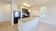 Located in the South Junction neighborhood of Memphis, Tennessee, this single-floor residence offers a clean, modern aesthetic throughout. The open-concept kitchen serves as a central hub, featuring granite countertops, dark espresso cabinetry, stainless steel appliances, and a peninsula with pendant lighting overhead. Large windows allow natural light to fill the adjoining living area, which opens directly onto a covered porch with white railings and pleasant views of the surrounding neighborhood and mature trees.

The bedrooms are bright and comfortable, with some featuring light wood-style flooring and others finished with soft wall-to-wall carpeting. Multiple windows dressed with white blinds allow natural light while maintaining privacy. The neutral wall tones create a calm, versatile backdrop throughout.

The bathroom is well-designed, offering a dark-cabineted vanity with a white countertop, a large mirror with overhead lighting, and a full tub-shower combination with chrome fixtures set against crisp white surrounds. Light wood-style tile flooring completes the clean, contemporary look.

A dedicated laundry area houses a full-size washer and dryer with overhead wire shelving for added storage. The overall design balances functionality and modern style, making this a practical and inviting space in a vibrant Memphis location.