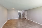 Located at 515 Gardere Ln in Baton Rouge, Louisiana, this two-story, one-bedroom, one-bathroom home offers a practical and well-organized layout across two floors. The main level features a generous living room with light hardwood-style flooring, neutral gray walls, and a textured ceiling, creating a clean and welcoming atmosphere. A staircase with a wooden railing connects to the upper level, while a hallway leads to the kitchen at the rear of the first floor. The kitchen is equipped with white cabinetry, marble-style countertops, black appliances including a range and a stainless steel refrigerator, and matching light hardwood-style flooring. Upstairs, the spacious bedroom is carpeted for comfort and features dual sliding closets, a ceiling fan with light fixture, multiple windows that invite natural light, and direct access to the full bathroom. The bathroom includes a tub-shower combination, a window for natural ventilation, dark hardwood-style flooring, and a vanity with warm wood cabinetry and a light-toned countertop. Throughout the home, consistent neutral tones and textured ceilings contribute to a cohesive, move-in-ready aesthetic.