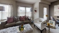 This single-floor residence in Oklahoma City, Oklahoma, offers a thoughtfully designed layout with modern finishes and a neutral color palette throughout. The living area welcomes natural light through large windows dressed with sheer curtains and horizontal blinds, creating a bright and comfortable atmosphere. Soft carpeting and warm-toned walls contribute to a relaxed, inviting ambiance.

The kitchen is well-equipped with white shaker-style cabinetry, dark granite countertops, stainless steel appliances including a range, microwave, and refrigerator, and a dishwasher. Wood-look tile flooring runs throughout the kitchen, which also features a breakfast bar with seating, providing a casual dining option.

The bedrooms are carpeted and generously proportioned, each offering ample closet space. The primary bedroom includes a walk-in closet and connects to a clean, functional bathroom featuring wood-look tile flooring, a tub/shower combination with white subway tile surround, and white cabinetry providing storage.

The floor plan, as seen in the dollhouse view, reflects an efficient open-concept arrangement connecting the kitchen, dining, and living areas seamlessly, making the overall space feel cohesive and functional for everyday living.