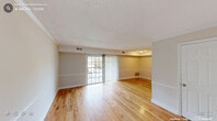 Located at 2723 Campus Walk Ave in Durham, NC, this single-floor, three-bedroom, two-bathroom home offers a functional and well-organized layout. Warm-toned hardwood floors run throughout the main living areas and bedrooms, creating a cohesive and inviting atmosphere. The open living room is bright and spacious, featuring sliding glass doors with vertical blinds that allow natural light to pour in while providing access to the outdoors. Crown molding and clean white baseboards add a polished touch to the neutral-toned walls.

The galley-style kitchen is efficiently designed with white cabinetry, granite-look countertops, a stainless steel sink, and white appliances including a refrigerator, dishwasher, and electric range. Tile flooring anchors the kitchen space, which connects seamlessly to the living area. The three bedrooms are comfortably sized, with the primary bedroom offering a generous footprint, and all rooms feature windows that bring in natural views of the surrounding greenery. Four closets throughout the home provide ample storage. The two bathrooms are clean and functional, each featuring a tub-shower combination with built-in shelving and white vanities, maintaining the home's consistent, bright aesthetic.