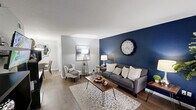 Located at 2300 S Highway 35 Bypass in Alvin, TX, this 1-bedroom, 2-bathroom residence delivers a thoughtfully organized single-floor layout that maximizes every inch of its compact footprint. The living room makes a bold first impression with a striking navy blue accent wall, wood-look flooring, and a large window dressed in sheer curtains that allows natural light to fill the space. An arched entryway leads into the dedicated dining area, which features a pendant light fixture and a decorative wall mirror, lending the space a polished, intimate feel. The galley-style kitchen is well-appointed with white cabinetry, quartz countertops, stainless steel appliances including a refrigerator and dishwasher, a double sink, and track lighting overhead. The bedroom offers comfortable carpeted flooring, a ceiling fan with light kit, a window for natural light, and the convenience of two separate closets for ample storage. Two bathrooms serve the unit, with one showcasing a wide vanity featuring white cabinetry, a quartz countertop, a lighted mirror, built-in shelving for storage, and a separate water closet. The overall aesthetic throughout is clean and cohesive, with a neutral gray palette accented by carefully chosen design details.