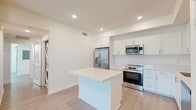 Located at 550 E Foothill Blvd in Rialto, CA, this well-designed 2-bedroom, 2-bathroom residence offers a clean, contemporary aesthetic throughout its single-floor layout. Light-toned luxury vinyl plank flooring flows seamlessly across the entire space, complementing the bright white walls and recessed lighting that keep every room feeling fresh and airy.

The open-concept kitchen is a standout feature, outfitted with crisp white shaker cabinetry, quartz countertops, a center island, and a full suite of stainless steel appliances including a range, microwave, dishwasher, and French door refrigerator. A dedicated pantry provides additional storage, while a stacked in-unit washer and dryer add everyday convenience.

The combined dining and living area offers generous open space with direct access to a private balcony, where sliding glass doors frame scenic mountain views. The primary bedroom is spaciously sized, benefiting from abundant natural light through large windows. The second bedroom also receives ample natural light through its own windows with blinds.

Both bathrooms are finished in a clean, modern style. The primary bath features a dual-sink vanity with gold-toned hardware and a large mirror, while the second bath includes a full tub-shower combination. Four closets throughout the residence ensure plentiful storage for all residents.