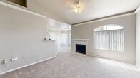 Located in Phoenix, AZ, this 2-bedroom, 3-bathroom single-story home offers a well-designed layout with a cohesive neutral palette throughout. The open living area is anchored by a tile-surround fireplace and framed by arched windows that allow generous natural light to fill the carpeted space. Vaulted ceilings and a ceiling fan add to the airy ambiance, while the connected dining area flows seamlessly into the kitchen.

The galley-style kitchen features white cabinetry with wood-tone accents, white countertops, and black appliances including a range and refrigerator. A peninsula with a breakfast bar bridges the kitchen to the living area, ideal for casual dining. Wood-look tile flooring runs throughout the kitchen, which also connects to an in-unit laundry area.

The primary bedroom is a comfortable retreat with plush carpet, high ceilings, and an arched doorway leading to an en-suite bathroom with a vanity. Additional bedrooms are well-sized with soft carpet and ample natural light. The three bathrooms are cleanly finished with wood-look tile flooring and tub-shower combinations with tiled surrounds.

Three closets provide generous storage throughout the home, and the thoughtfully connected hallway ties all rooms together for smooth, practical circulation.