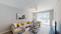 This single-floor residence is thoughtfully designed with a modern, open layout that connects key living areas seamlessly. The living room serves as a welcoming centerpiece, finished with light wood-style flooring, a textured ceiling, and a ceiling fan that enhances airflow and comfort. Large sliding glass doors fitted with vertical blinds open to an outdoor patio, allowing generous natural light to fill the space. The room flows naturally toward a dedicated media area, which also provides direct sightlines to the bedroom.

The kitchen is a standout feature, showcasing dark espresso cabinetry contrasted by a white subway tile backsplash and granite-topped island with bar seating. Stainless steel appliances, including a refrigerator, range, and microwave, add a polished, functional quality. A built-in wine rack above the upper cabinets adds a distinctive touch. Adjacent to the kitchen, the dining area is defined by a pendant light overhead and offers a comfortable space for everyday meals.

The bathroom is finished with a wide marble-style countertop hosting dual undermount sinks, chrome fixtures, and large mirrors that enhance the sense of space and brightness. Throughout, neutral tones and consistent flooring choices contribute to a cohesive and well-maintained interior.