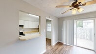 This two-story townhouse in Augusta, Georgia, offers a practical and comfortable layout spread evenly across two floors. The main level features an open living area with durable wood-style flooring, neutral gray walls, and a textured ceiling with a ceiling fan. A pass-through counter connects the living space to the kitchen, which is well-equipped with stainless steel appliances — including a range, refrigerator, and dishwasher — white cabinetry, light countertops, and a double sink. Natural light filters in through windows near the entry door, creating a bright and welcoming atmosphere. Sliding glass doors in the living area provide additional light and outdoor access. The upper floor houses the two bedrooms, each carpeted for comfort and fitted with ceiling fans. The spacious primary bedroom includes a built-in closet with shelving and rod storage. The second bedroom also features its own closet. A full bathroom with a tub/shower combination serves the upper level. A hallway connects the upstairs rooms, completing the functional layout. Throughout, clean white trim and a consistent neutral palette give the townhouse a tidy, move-in-ready feel.