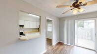 This two-story townhouse in Augusta, Georgia, offers a practical and comfortable layout spread evenly across two floors. The main level features an open living area with durable wood-style flooring, neutral gray walls, and a textured ceiling with a ceiling fan. A pass-through counter connects the living space to the kitchen, which is well-equipped with stainless steel appliances — including a range, refrigerator, and dishwasher — white cabinetry, light countertops, and a double sink. Natural light filters in through windows near the entry door, creating a bright and welcoming atmosphere. Sliding glass doors in the living area provide additional light and outdoor access. The upper floor houses the two bedrooms, each carpeted for comfort and fitted with ceiling fans. The spacious primary bedroom includes a built-in closet with shelving and rod storage. The second bedroom also features its own closet. A full bathroom with a tub/shower combination serves the upper level. A hallway connects the upstairs rooms, completing the functional layout. Throughout, clean white trim and a consistent neutral palette give the townhouse a tidy, move-in-ready feel.