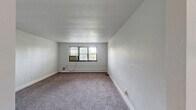 Located at 4410 Township Line Road in Drexel Hill, PA, this one-bedroom, one-bathroom unit offers a well-organized single-floor layout across a comfortable footprint. The space includes a living room, dining area, kitchen, hallway, two closets, and a full bathroom.

The kitchen stands out as a highlight, featuring crisp white shaker-style cabinetry extending to the ceiling, marble-look countertops, a mosaic tile backsplash, stainless steel appliances including a full-size refrigerator and range, and warm hardwood-style flooring — a clean, modern aesthetic that contrasts pleasantly with the rest of the unit.

The living and bedroom areas are finished with neutral-toned carpet and bright white walls, creating a clean, move-in-ready feel. Drop-panel ceilings are consistent throughout, and baseboard heating runs along the perimeter of the main rooms. Multiple windows allow natural light to filter in and provide outdoor views of the surrounding neighborhood. A wall-mounted air conditioning unit serves the bedroom.

The spacious primary bedroom includes a large double-door closet with a full-width hanging rod, offering generous storage. An additional closet provides further organizational flexibility.

The bathroom features retro-style salmon and black tilework surrounding the tub/shower combo, complemented by a modern pedestal sink, wood-look flooring, and a bright window with slatted blinds.