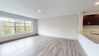 Located at 3490 Whitney Ave in Hamden, Connecticut, this single-floor residence combines modern design with functional living. The open-concept layout seamlessly connects the living area to the kitchen, creating a spacious and cohesive flow throughout. Durable wood-look plank flooring runs throughout the unit, providing a warm yet contemporary aesthetic.

The kitchen is equipped with rich, dark espresso cabinetry, light granite-style countertops, and a full suite of stainless steel appliances, including a refrigerator and electric range. A peninsula counter defines the kitchen space while offering additional prep and seating potential.

The generously sized living area is bathed in natural light, courtesy of large windows that frame lush, wooded views — a standout feature of this unit. Additional rooms, ideal for bedrooms or flexible living spaces, also benefit from these scenic green views and share the same bright, neutral palette with clean white walls and modern trim.

The bathroom is finished with a full soaking tub and shower combination with sleek white surround walls and contemporary chrome fixtures. The primary bedroom is notably well-appointed, featuring dual closets for ample storage. Throughout the unit, neutral tones, clean lines, and quality finishes create a bright, move-in-ready environment.