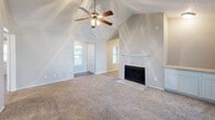 Located at 10010 Whitehurst Dr in Dallas, TX, this single-story, 3-bedroom, 2-bathroom home offers a functional and comfortable layout with a variety of notable architectural details. The living room serves as the heart of the home, featuring soaring vaulted ceilings, a ceiling fan, plush carpet flooring, and a classic fireplace with a white mantel — creating a warm and inviting atmosphere. Natural light filters in through multiple windows fitted with blinds throughout the home.

The dining area adjoins the kitchen and is highlighted by wood-look plank flooring, a stylish chandelier, and a trio of windows that bring in ample daylight. The kitchen is well-appointed with white cabinetry, dark countertops, white appliances including a refrigerator, range, and dishwasher, and a window above the sink.

The spacious primary bedroom features vaulted ceilings, a ceiling fan, carpet flooring, French doors leading to an outdoor balcony, and a connected en-suite bathroom with a vanity and shower. Two additional bedrooms are accessible via a carpeted hallway with multiple closets providing generous storage. Both bathrooms include vanities and hardwood-style flooring. A dedicated laundry room with washer and dryer hookups rounds out this practical and well-designed home.