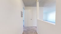 Located at 10625 Petit Ave in the Granada Hills neighborhood of Los Angeles, this one-bedroom, two-bathroom unit offers a practical and well-organized single-floor layout. The combined kitchen and living area features light wood-look flooring throughout, with the kitchen equipped with white cabinetry, granite-style countertops, a black gas range, and an over-the-range ventilation hood. A dedicated dining space adjacent to the kitchen provides additional versatility. The living room is carpeted and features a large window that draws in natural light while offering views of the surrounding neighborhood. A wall-mounted air conditioning unit ensures year-round comfort. The bedroom is a well-proportioned retreat with plush carpeting, a textured ceiling, and a full-width mirrored sliding closet that adds a sense of depth to the room. The two bathrooms include a vanity bathroom with white cabinetry and a wide mirror, and a full bathroom with wood-look flooring, a combined tub and shower with a handheld showerhead, and clean white finishes throughout. A hallway connecting the rooms features an electrical panel access point and a textured ceiling consistent with the rest of the unit. The overall aesthetic is clean, neutral, and move-in ready.