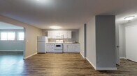 Located at 2136 West Riverside Avenue in Spokane, WA, Unit 331 is a well-appointed single-floor residence that combines practical design with clean, modern finishes. Wood-look plank flooring runs throughout the entire unit, providing a cohesive and durable foundation in every room.

The kitchen is thoughtfully arranged with white cabinetry, light granite-style countertops, and white appliances including a refrigerator, electric range with over-the-range microwave, and a sink — all set against neutral gray walls that keep the space feeling bright and open.

The living and common areas offer generous, open square footage with neutral gray walls and flush-mount lighting, providing a versatile canvas for a variety of furniture arrangements. The floor plan, as visible in the dollhouse view, includes multiple private rooms separated by interior doors featuring classic six-panel and two-panel designs with brushed nickel hardware.

The bedroom features two windows that bring in natural light and offer views of the surrounding Spokane cityscape. An additional room provides flexible use as a second bedroom, office, or storage space.

The bathroom is finished with wood-look flooring, a white vanity with granite-style countertop, brushed nickel fixtures, and a shower/tub combination. Clean white walls and crisp trim complete the look throughout, making this a well-maintained and move-in-ready space.