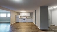 Located at 2136 West Riverside Avenue in Spokane, WA, Unit 331 is a well-appointed single-floor residence that combines practical design with clean, modern finishes. Wood-look plank flooring runs throughout the entire unit, providing a cohesive and durable foundation in every room.

The kitchen is thoughtfully arranged with white cabinetry, light granite-style countertops, and white appliances including a refrigerator, electric range with over-the-range microwave, and a sink — all set against neutral gray walls that keep the space feeling bright and open.

The living and common areas offer generous, open square footage with neutral gray walls and flush-mount lighting, providing a versatile canvas for a variety of furniture arrangements. The floor plan, as visible in the dollhouse view, includes multiple private rooms separated by interior doors featuring classic six-panel and two-panel designs with brushed nickel hardware.

The bedroom features two windows that bring in natural light and offer views of the surrounding Spokane cityscape. An additional room provides flexible use as a second bedroom, office, or storage space.

The bathroom is finished with wood-look flooring, a white vanity with granite-style countertop, brushed nickel fixtures, and a shower/tub combination. Clean white walls and crisp trim complete the look throughout, making this a well-maintained and move-in-ready space.