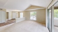 Located in Bradenton, FL, this single-floor residence offers four bedrooms and three bathrooms within a well-organized layout. The living area immediately impresses with its vaulted, angled ceiling that creates an open, airy atmosphere, complemented by plush carpeting and multiple windows that invite natural light and outdoor views of the surrounding greenery. A chandelier adds a refined touch to the space.

The kitchen is thoughtfully designed with white shaker-style cabinetry, light countertops, a stainless steel refrigerator, and a stainless electric range with an overhead ventilation hood. A pass-through counter connects the kitchen to the living area, enhancing the open-concept feel and making it ideal for everyday functionality. Durable wood-look flooring grounds the kitchen space.

Each bedroom is finished with neutral-toned walls and soft carpeting, providing a calm and comfortable environment. The bedrooms include closets with bifold doors, and the primary suite features a dedicated walk-in closet with built-in shelving. The bathrooms are clean and functional, featuring full tub-shower combinations, large vanity mirrors, and speckled countertops. A ceiling fan is present in select bedrooms, adding to year-round comfort in this Florida home.