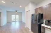 This 880 square foot apartment in Florida City, FL offers a contemporary living space with two bedrooms and two bathrooms. The single-story layout maximizes efficiency, with the primary bedroom measuring a comfortable 170 square feet. The heart of the home is an open-concept living area that seamlessly integrates the kitchen and living room. The kitchen boasts rich, dark wood cabinetry, contrasting beautifully with light countertops and modern black appliances. Throughout the apartment, light-toned wood-look flooring creates a warm, inviting atmosphere. Both bathrooms feature clean lines and neutral colors, with one offering a combination tub-shower. Large windows in the bedrooms and living areas allow ample natural light, while ceiling fans provide air circulation. Outside, residents can enjoy a fenced yard area with lush vegetation, including palm trees, creating a tropical Florida ambiance. The property at 480 NE 3rd St, 104, combines modern conveniences with a touch of coastal charm, offering a comfortable living space in a desirable location.