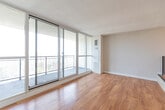 Located at 200 Bay St S in Hamilton, Ontario, this two-bedroom, one-bathroom unit offers a well-organized layout across a single floor. Warm hardwood flooring flows throughout the main living areas and bedrooms, complemented by neutral-toned walls and textured ceilings that add character to the space.

The living area is a standout feature, showcasing expansive floor-to-ceiling windows and access to a balcony that frames elevated views of the Hamilton cityscape, filling the room with abundant natural light. The primary bedroom is a comfortable size, also benefiting from large windows with sweeping city views, while the second bedroom provides additional flexibility for guests or a home office.

The kitchen is thoughtfully appointed with warm wood cabinetry, granite countertops, a classic white subway tile backsplash, a double stainless steel sink, and tile flooring — offering both functionality and style. A dedicated hallway connects the rooms and provides access to the full bathroom, which features matching granite countertop vanity, tile flooring, and a full soaker tub-shower combination enclosed by crisp white subway tile.

The unit's layout is efficient and practical, making excellent use of its footprint to deliver a comfortable living experience in the heart of Hamilton's urban core.