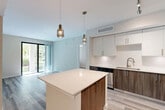 Located at 15556 SW 127th Ave in Miami, FL, this well-appointed 3-bedroom, 2-bathroom residence offers a thoughtfully designed single-floor layout with modern finishes throughout. The open-concept kitchen is a standout feature, showcasing two-tone cabinetry with white upper cabinets and warm wood-grain lower cabinets, quartz countertops, a subway tile backsplash, and a full suite of stainless steel appliances including a refrigerator, range, and built-in microwave. A central kitchen island with pendant lighting provides additional prep space and flows seamlessly into the living area, which is bathed in natural light from sliding glass doors that open to a private balcony with green outdoor views. Light wood-look flooring runs throughout the main living areas and bedrooms, complementing the clean, neutral palette. The spacious primary bedroom features dual windows, a ceiling fan, and ample natural light. A dedicated walk-in closet with wire shelving provides generous storage. Both bathrooms are finished with tile flooring, wood-grain vanities, white quartz countertops, and tub-shower combinations with white tile surrounds. A connecting hallway with wood-look flooring links the bedrooms to the main living areas, completing this cohesive and modern Miami home.