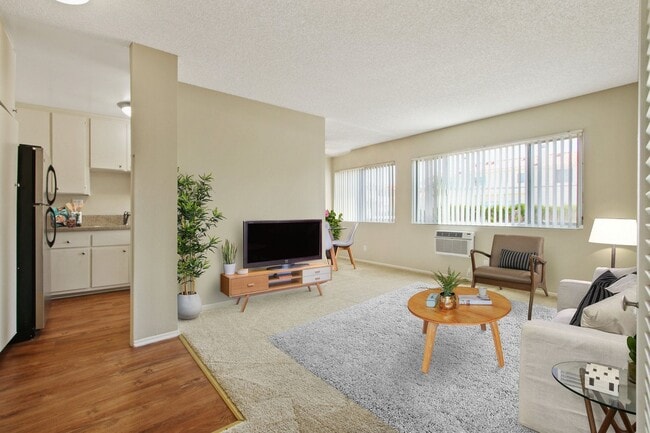 Living room with carpeted floors and Kitchen area with wood inspired floors - Seville Townhouse