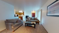 Located at 105 Lisa Street in Rincon, Georgia, this single-story home offers a comfortable and functional layout across a variety of well-appointed spaces. The living area is bright and welcoming, featuring large vertical blinds that allow generous natural light to filter in, soft carpeted floors, and an open flow into adjacent rooms. A second living space mirrors this layout with similarly carpeted floors and vertical blinds, providing additional flexibility for everyday use. The kitchen is designed for practicality, featuring warm-toned wooden cabinetry that extends to the ceiling for ample storage, light countertops, a double sink, a dishwasher, electric range, and a full-size refrigerator. The tile flooring adds durability to the space. The full bathroom includes a wide dual-sink vanity with a large mirror, a tub-shower combination, and tile flooring, offering a clean and functional design. The home features multiple bedrooms, each equipped with ceiling fans with light fixtures and plush carpeted floors. Several bedrooms include closets with open shelving, and windows allow natural light to brighten each room, contributing to a comfortable and restful atmosphere throughout the residence.