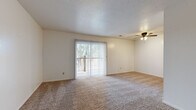 Located at Belmont St in Liberty, MO, this single-floor, one-bedroom, one-bathroom unit offers a practical and comfortable layout across a modest, well-organized floor plan. The living room serves as the heart of the space, featuring soft wall-to-wall carpeting, a ceiling fan with light fixture, a textured ceiling, and a large sliding glass door dressed with vertical blinds that opens to an outdoor balcony, filling the room with natural light and outdoor views. The kitchen is equipped with warm-toned wood cabinetry, a gas range, dishwasher, refrigerator, and tile backsplash, all set atop durable stone-patterned tile flooring, providing ample storage and counter space for everyday cooking. The bedroom is a comfortable, carpeted room with a natural window and notable storage — featuring two side-by-side closets with bifold doors, offering generous organizational capacity. A hallway connects the main living areas to the full bathroom, which includes a tub-shower combination with a clean white surround, tile flooring, and essential fixtures. Neutral tones and clean finishes throughout the unit create a calm, cohesive ambiance well-suited for single occupancy or a couple.