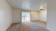 Located at Belmont St in Liberty, MO, this single-floor, one-bedroom, one-bathroom unit offers a practical and comfortable layout across a modest, well-organized floor plan. The living room serves as the heart of the space, featuring soft wall-to-wall carpeting, a ceiling fan with light fixture, a textured ceiling, and a large sliding glass door dressed with vertical blinds that opens to an outdoor balcony, filling the room with natural light and outdoor views. The kitchen is equipped with warm-toned wood cabinetry, a gas range, dishwasher, refrigerator, and tile backsplash, all set atop durable stone-patterned tile flooring, providing ample storage and counter space for everyday cooking. The bedroom is a comfortable, carpeted room with a natural window and notable storage — featuring two side-by-side closets with bifold doors, offering generous organizational capacity. A hallway connects the main living areas to the full bathroom, which includes a tub-shower combination with a clean white surround, tile flooring, and essential fixtures. Neutral tones and clean finishes throughout the unit create a calm, cohesive ambiance well-suited for single occupancy or a couple.
