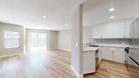 Located at 7918 Reseda Blvd in the Reseda neighborhood of Los Angeles, this thoughtfully designed 3-bedroom, 3-bathroom unit offers a clean, modern aesthetic across a single floor. Light wood-style flooring flows throughout, complementing the neutral warm-gray walls and crisp white trim found in every room.

The open-concept kitchen and living area serves as the heart of the unit. The kitchen features white shaker-style cabinetry, light quartz countertops, gray tile backsplash, and stainless steel appliances including a refrigerator, microwave, and dishwasher. A peninsula counter separates the kitchen from the living area, which is bathed in natural light from a sliding glass door leading to a private outdoor patio. The patio offers a generous concrete surface enclosed by a wood-panel privacy fence.

Each of the three bedrooms features the same light flooring and neutral tones, with the spacious primary bedroom benefiting from its own sliding glass door with outdoor access. The three bathrooms are finished with white vanity cabinetry, quartz countertops, brushed nickel fixtures, and a clean, contemporary feel. A hallway and closet complete the layout, ensuring practical storage and smooth circulation throughout this well-appointed home.