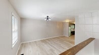 Located at 4152 Cherrywood Dr in Hudson, NC, this two-story home offers 2 bedrooms and 3 bathrooms across two well-proportioned floors. Light wood-look flooring runs throughout, creating a clean, cohesive aesthetic complemented by neutral wall tones and contemporary fixtures.

The kitchen is a standout feature, showcasing dark gray cabinetry, quartz-style countertops, a tile backsplash, stainless steel appliances, and a statement geometric pendant light — all illuminated by natural light from a window overlooking the greenery outside. The lower floor also includes a living area with a drop ceiling, bold dark-framed French doors that open to the outdoors, and convenient access to the wooded backyard.

The bathrooms are thoughtfully appointed with vessel sinks, marble-look vanity tops, matte black hardware, and stylish wall-mounted lighting. The primary bedroom is a comfortable and well-sized retreat, while the second bedroom features a decorative ceiling fan-light fixture and a window drawing in natural daylight.

A private deck extends the living space outdoors, offering peaceful views of the surrounding mature trees and lush vegetation — a serene natural setting that defines the character of this Hudson, NC home.