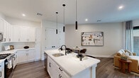 Located in East Brunswick, NJ, this well-appointed one-bedroom, one-bathroom residence offers a modern and cohesive design throughout its efficiently laid-out single floor. The open-concept kitchen and living area serves as the heart of the home, where a bright, white shaker-style kitchen impresses with stainless steel appliances, a decorative tile backsplash, abundant cabinetry, and a large island with pendant lighting and bar seating — ideal for both everyday meals and entertaining. The adjacent living room is warm and inviting, featuring wood-tone flooring, clean white walls, and sliding glass doors that open directly onto a private tiled patio, filling the space with natural light and providing a seamless indoor-outdoor connection. The bedroom is a serene retreat with soft neutral tones, a ceiling fan, sliding glass door access to the outdoors, and generous closet storage with double bifold doors. The bathroom is finished with large-format gray tile in the tub-shower surround, matte black fixtures, and a clean white vanity. A dedicated in-unit laundry closet with a stacked washer and dryer adds everyday convenience, completing this thoughtfully designed residence.