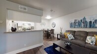 This single-story residence offers a thoughtfully designed open-concept layout that seamlessly connects the living, dining, and kitchen areas. The living room is bright and welcoming, featuring rich hardwood-style flooring, large windows that invite natural light, and ample space for comfortable seating. A dedicated dining area sits adjacent to the living room, defined by its own corner space and accented with decorative wall art, making it an ideal spot for everyday meals or entertaining guests.

The galley-style kitchen is efficiently designed with white cabinetry, granite-style countertops, and stainless steel appliances including a refrigerator, electric range, and dishwasher. A pass-through counter connects the kitchen to the main living area, enhancing the open feel of the floor plan.

The unit includes two bedrooms, each finished with plush carpeting. The primary bedroom features a ceiling fan, a window with natural light, and generous space for a full bedroom suite. The second bedroom also offers comfortable proportions with closet access. The bathroom is clean and functional, featuring a full tub and shower combination with white tile surround and chrome fixtures. Neutral tones and consistent finishes throughout create a cohesive and inviting atmosphere.