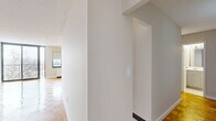 Located on the 10th floor at 185 Prospect Ave in Hackensack, NJ, this well-appointed 2-bedroom, 2-bathroom residence offers a generous and thoughtfully designed single-level layout. Distinctive parquet wood flooring flows throughout the living areas and bedrooms, lending warmth and classic character to the space. The expansive living room is bathed in natural light through large windows and sliding glass doors that open onto a private balcony, offering elevated outdoor views of the surrounding area. The kitchen is outfitted with rich, wood-toned cabinetry, granite countertops, stainless steel appliances including a gas range and dishwasher, and tile flooring — combining style with practicality. Both bedrooms are well-proportioned, with the primary bedroom providing a notably generous footprint, and each room benefiting from natural light and access to ample closet space. With six closets total throughout the residence, storage is abundant. The two full bathrooms each feature a tub-shower combination with white tile surrounds and clean, neutral finishes. A dedicated hallway connects the living spaces efficiently, and the overall palette of soft whites and warm wood tones creates a bright, cohesive ambiance throughout.