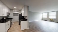 This one-bedroom, one-bathroom residence at 498 Sherwood Place in Stratford, Connecticut offers a clean, modern layout designed for comfortable everyday living. The open-concept living area is finished with light wood-tone luxury vinyl plank flooring that runs throughout the unit, complemented by soft gray walls and bright white trim, creating a fresh and neutral aesthetic.

The galley-style kitchen is thoughtfully appointed with white shaker cabinetry, dark granite countertops, and stainless steel appliances including a refrigerator, range, and microwave. A basin sink with modern fixtures anchors the countertop space, while recessed lighting provides functional illumination throughout the kitchen corridor. A walk-in closet is accessible directly from the kitchen area, offering generous storage.

The living area is spacious and open, benefiting from natural light through a window, and is equipped with a baseboard heating system. The seamless flow between the kitchen and living space makes the layout feel expansive and versatile.

The bathroom features a full tub and shower combination surrounded by classic white subway tile, paired with chrome fixtures for a timeless, clean finish. The overall design of this residence prioritizes modern updates and functional simplicity, making it a well-appointed home in the Stratford community.
