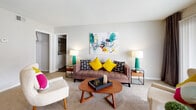 Located at 6615 The Lakes Dr in Raleigh, NC, this single-floor residence offers a well-organized layout designed for comfortable living. The open living and dining area serves as the heart of the home, featuring plush carpeting, a ceiling fan, and large sliding glass doors that invite generous natural light and provide access to an outdoor area. The living space is thoughtfully arranged with room for both lounging and dining, creating a seamless flow between the two areas.

The kitchen is efficiently designed with white cabinetry, light stone countertops, a breakfast bar with seating, and wood-style flooring. Black appliances including a refrigerator, dishwasher, and range complete the functional cooking space.

The residence includes multiple bedrooms, each finished with soft carpet, neutral gray walls, and built-in closets offering ample storage. The bedrooms receive natural light through windows dressed with curtains, creating a calm and restful atmosphere.

The bathroom features wood-style flooring, a white vanity with stone countertops, and a tub-shower combination. Consistent use of neutral tones with bold accent colors is carried throughout the home, giving the space a cohesive and lively character. Overall, this residence balances practicality with a vibrant, modern aesthetic.