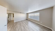 This well-designed two-bedroom, one-bathroom unit offers a practical and comfortable single-floor layout. The open living area is bright and airy, featuring light-toned wood-look flooring, neutral wall tones, and a textured ceiling. A large window invites natural light, creating a welcoming atmosphere throughout the main living space.

The kitchen is efficiently laid out with rich dark-wood cabinetry, granite-style countertops, a double stainless steel sink, and a full suite of appliances including an electric range. The light flooring continues here, maintaining a cohesive aesthetic.

Both bedrooms are carpeted for comfort and feature ceiling fans with light fixtures. Each room includes a closet with built-in shelving and hanging rods for organized storage. The rooms are finished in soft neutral tones, offering a calm and restful environment.

The bathroom is tastefully appointed with marble-look tile surrounding the full soaking tub and shower, complemented by a granite-topped vanity and wood-look flooring. A hallway connects the main areas of the unit, contributing to a logical and functional flow throughout.

Overall, this unit offers a clean, move-in ready space with consistent finishes, ample natural light, and thoughtful storage solutions throughout.