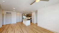 Located at 4245 Bobtown Rd in Garland, TX, this well-designed 2-bedroom, 2-bathroom single-floor residence offers a clean, contemporary aesthetic throughout. The open-concept living area is anchored by a bright, modern kitchen featuring gray shaker-style cabinetry, a white quartz center island with an undermount sink, stainless steel appliances including a French door refrigerator, electric range, and built-in microwave, complemented by a white subway tile backsplash. Elegant pendant lights hang above the island, while recessed lighting and a ceiling fan enhance the adjoining living and dining areas. Light wood-style luxury vinyl plank flooring flows throughout the main living spaces, creating a warm, cohesive look. The living area offers access to a private balcony through a glass-panel door, with large windows that invite abundant natural light and outdoor views. Both bedrooms are carpeted for comfort, each equipped with a ceiling fan and generous windows. The primary bedroom features its own bathroom and a walk-in closet with built-in shelving. Additional highlights include multiple closets, a dedicated laundry area, and a utility room, ensuring practical, everyday convenience throughout this thoughtfully arranged home.