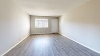 Located at 2572 Lenox Rd NE in Atlanta's 30324 zip code, this single-floor, three-bedroom, one-bathroom residence offers a practical and well-organized layout. The open-concept living, dining, and kitchen area serves as the heart of the home, featuring durable hardwood-style flooring throughout and neutral gray-toned walls that create a clean, versatile backdrop. The kitchen is outfitted with white shaker-style cabinetry, granite-look countertops, a subway tile backsplash, stainless steel dishwasher, and an electric range — all complemented by hardwood-style flooring that flows seamlessly into the main living area. Natural light enters through windows in the living space, enhancing the open feel. A connecting hallway leads to the three bedrooms, each finished with plush wall-to-wall carpeting and individual closets, providing ample storage. The generously sized primary bedroom offers comfortable proportions and its own dedicated closet. The full bathroom is finished with white tile and includes both a tub/shower combo and a separate walk-in shower. Additional storage is available via a pantry. The unit's neutral palette and consistent finishes throughout create a cohesive, move-in-ready atmosphere.