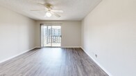 Located at 829 NW 79th Ter in Kansas City, MO, this well-appointed one-bedroom, one-bathroom residence offers a functional and comfortable single-floor layout. The open-concept living and dining area features durable hardwood-style flooring, neutral wall tones, and a ceiling fan with light fixture, creating a bright and airy atmosphere. A sliding glass door leads to a private balcony, bringing in natural light and offering views of the surrounding community. The kitchen is thoughtfully designed with a pass-through breakfast bar that opens to the living space, white cabinetry, a stainless steel refrigerator, and a gas range, making it ideal for everyday cooking and casual entertaining. A hallway connects the main living area to the private bedroom, which is generously sized and finished with plush carpet, a ceiling fan, and a dedicated closet offering ample storage. The bathroom features a full-size tub and shower combo with clean white surrounds. Textured ceilings throughout add a classic residential character, while the neutral color palette and consistent finishes create a cohesive and move-in-ready feel across the entire space.