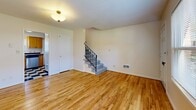 Located in Portland, OR, this multi-level, 1-bedroom, 1-bathroom home spans three floors, offering a well-organized layout with distinct living zones. The entry level welcomes you through a classic paneled front door into a bright foyer with light-toned hardwood floors and a staircase with a sleek black metal railing leading to the upper level. The main living area is spacious and bright, bathed in natural light from neighborhood-facing windows, and features warm hardwood flooring throughout. The kitchen is outfitted with natural wood cabinetry, dark tile countertops, a bold black-and-white checkered floor, and stainless steel appliances including a refrigerator, electric range, and dishwasher. The generously sized bedroom offers a window with outdoor views and access to multiple closets, providing ample storage. The full bathroom includes a white vanity with under-cabinet storage, a tub-shower combination with white tile surround, and a round mirror with elegant vanity lighting. The lower level houses a utility room with a water heater and exposed structural beams, serving as practical additional space. With four closets distributed throughout, this home offers excellent storage capacity across all levels.